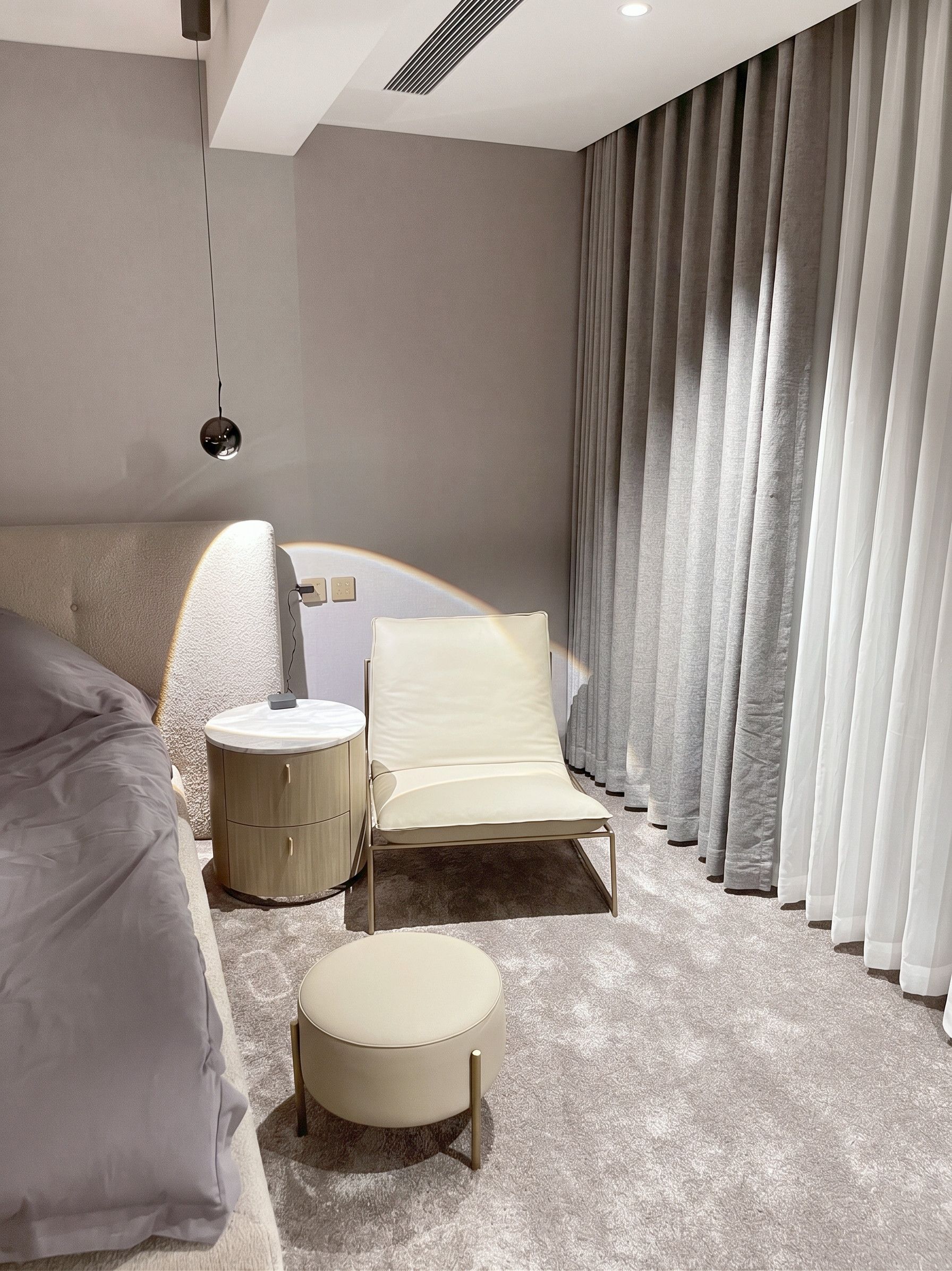 Bedroom corner — lounge chair, ottoman, curved nightstand